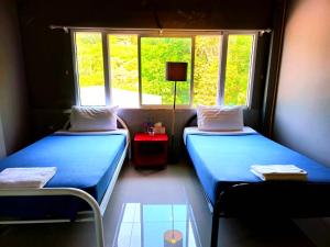 two beds in a room with two windows at Hotel595Kohchang in Ban Map Khangkhao