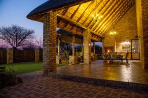 a brick pavilion with a table and chairs on a patio at Sondela Nature Reserve & Spa Makhato Lodges in Bela-Bela