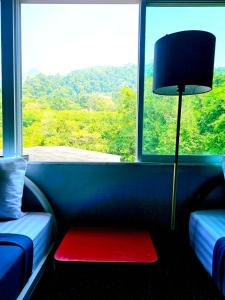 a room with a table and a lamp in front of a window at Hotel595Kohchang in Ban Map Khangkhao