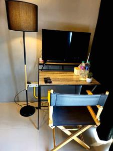a desk with a television and a chair in a room at Hotel595Kohchang in Ban Map Khangkhao