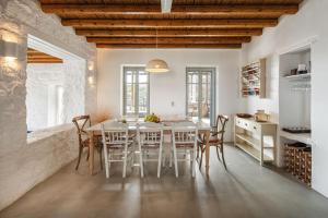 cocina y comedor con mesa y sillas en Infinity Villa, luxury house with stunning view in Serifos, en Rámos