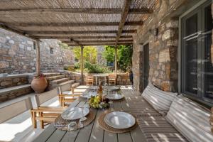 un patio con mesa y sillas en un edificio en Infinity Villa, luxury house with stunning view in Serifos, en Rámos