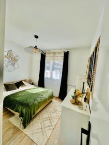 a bedroom with a green bed and a table at Coquet appartement in Canet-en-Roussillon