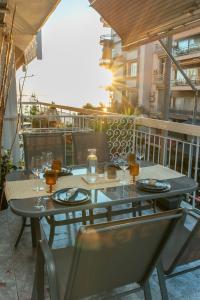une table avec des assiettes et des verres sur un balcon dans l'établissement Houseloft Koromila Sea View, à Thessalonique