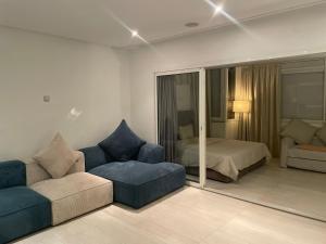 ein Wohnzimmer mit einem Sofa und einem Bett in der Unterkunft Central, terrasse, confortable - Bleue résidence in Casablanca
