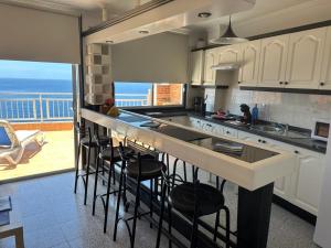 eine Küche mit einer Theke und Meerblick in der Unterkunft Vivienda Vacacional con Vistas a La Gomera y La Palma in Puerto de Santiago