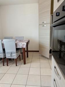 eine Küche mit einem Tisch und Stühlen in der Unterkunft MANZONI APARTS - Comfort SUITE in San Pellegrino Terme