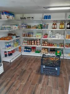 un pasillo de una tienda de comestibles con estanterías de comida en Auberge du Cap en Cilaos