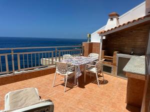 eine Terrasse mit einem Tisch und Stühlen auf dem Balkon in der Unterkunft Vivienda Vacacional con Vistas a La Gomera y La Palma in Puerto de Santiago