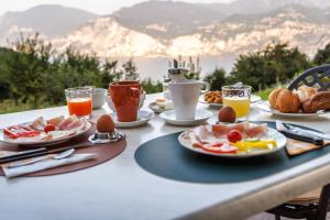 einen Frühstückstisch mit Frühstückszutaten und Getränken darauf in der Unterkunft Agriturismo San Maggiore in Malcesine