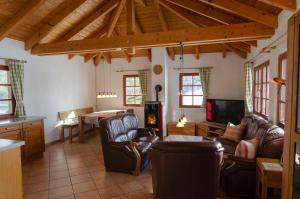 a living room with leather chairs and a television and a table at Das Ferienhaus Mondschein im Land der tausend Berge - Erholung Pur in idyllischer Alleinlage in Lennestadt