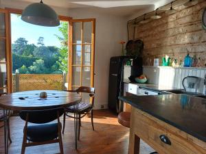 uma cozinha com uma mesa de madeira e uma sala de jantar em The Riverview Loft em Sainte-Foy-la-Grande