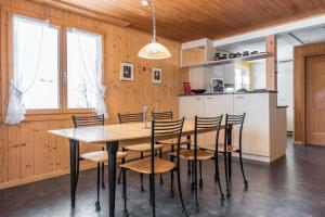 a kitchen and dining room with a table and chairs at Apartment Obem Doregade - GRIWA RENT AG in Grindelwald