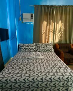 een slaapkamer met een bed met twee slippers erop bij Rozay Travellers Inn in Kabankalan