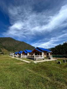 Dirang Dzong的住宿－Letro Homestay，一片田野上一排蓝色屋顶的房子
