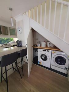 a kitchen with a washing machine under a staircase at Townhouses by the Beach in Thirroul +18 photos