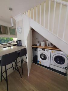 a kitchen with a washing machine under a staircase at Townhouses by the Beach in Thirroul