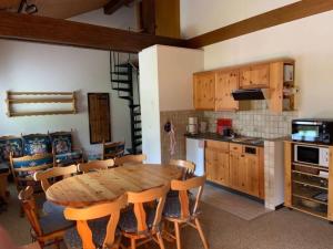 eine Küche und ein Esszimmer mit einem Holztisch und Stühlen in der Unterkunft Résidence A9 - Les Myosotis in Les Mosses