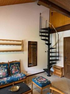 ein Wohnzimmer mit einer Wendeltreppe und einer Couch in der Unterkunft Résidence A9 - Les Myosotis in Les Mosses