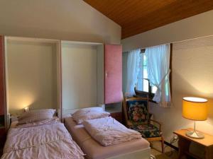 a bedroom with two beds and a lamp and a window at Résidence A9 - Les Myosotis in Les Mosses