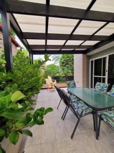 a patio with a glass table and chairs at Townhouses by the Beach in Thirroul