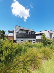 a building on top of a field of grass at Townhouses by the Beach in Thirroul