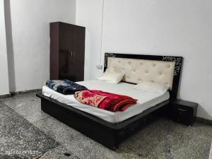 sypialnia z łóżkiem z czarnym zagłówkiem w obiekcie OH TEN SPOON HOTEL w mieście Samālkha