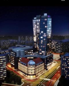 um grande edifício com luzes acesas numa cidade à noite em HANZA TOWER Apartments White Sky 16 to 26th floor POOL & SPA em Szczecin