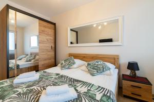 a bedroom with a bed and a mirror at Apartament z dwoma sypialniami i z miejscem postojowym in Białystok
