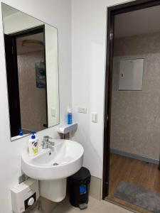 a bathroom with a sink and a mirror and a shower at Abreeza Place T2 - 720 in Davao City