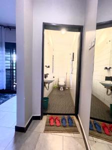 a bathroom with a toilet and red shoes on the floor at Ashleys Hotel in Kampala