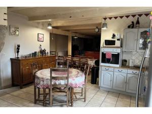 cocina y comedor con mesa y sillas en Maison de Famille de 1823, en Chastreix