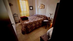 1 dormitorio con 1 cama y 1 silla en una habitación en La Rosa Blu, en Goriano Sicoli
