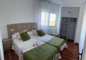 sypialnia z dużym łóżkiem z zielonymi poduszkami w obiekcie Viviendas vacacionales as lagas w mieście Palas de Rei 