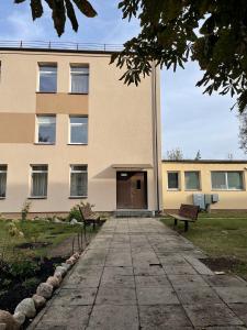 een gebouw met twee banken ervoor bij Cozy two-room apartment in Druskininkai