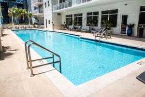 a swimming pool with blue water in a building at Bnb Hyperion - Ocean View - 3BR Condo w Pool & GYM in Miami