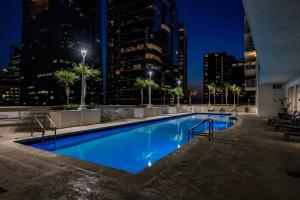 a swimming pool with a city skyline at night at Bnb Hyperion - Ocean View - 3BR Condo w Pool & GYM in Miami