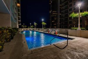 a swimming pool in a city at night at Bnb Hyperion - Ocean View - 3BR Condo w Pool & GYM in Miami