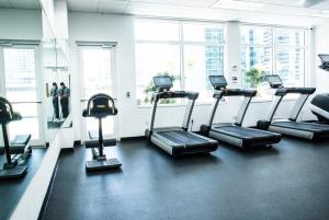 a gym with cardio machines in a room with windows at Bnb Hyperion - Ocean View - 3BR Condo w Pool & GYM in Miami