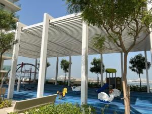 um pavilhão com um parque infantil com uma montanha-russa em Silkhaus Tower with Private Beach in Exclusive Location no Dubai