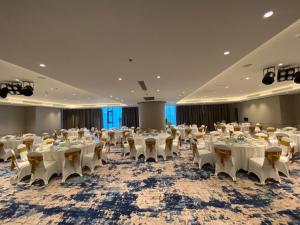 un salón de banquetes con mesas y sillas en una habitación en View Natural Wonders A La Carte Ha Long Bay VIE, en Ha Long