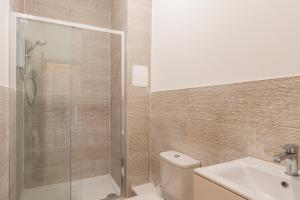 uma casa de banho com um chuveiro, um WC e um lavatório. em Seaside Bliss - Seafront Apartments em Kent