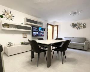 a dining room and living room with a table and chairs at APPARTAMENTO PICASSO in Villasimius