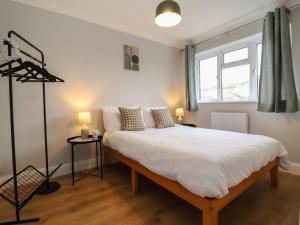 ein Schlafzimmer mit einem großen weißen Bett mit zwei Lampen in der Unterkunft Herring House in Lowestoft