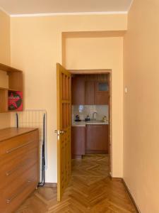 een kleine kamer met een keuken en een deur bij Cozy two-room apartment in Druskininkai