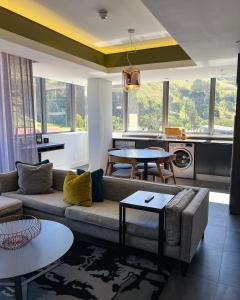 ein Wohnzimmer mit einem Sofa und einem Tisch in der Unterkunft The Capital Mirage in Kapstadt