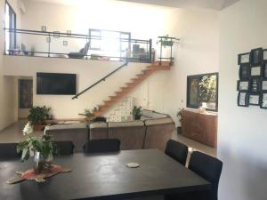 a living room with a table and a staircase at Kaz Ajeya in Les Avirons