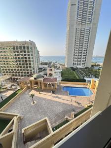 a view of a building with a pool and buildings at Bollywood Beach Hostel in Dubai