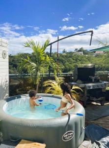 two children playing in a jacuzzi tub on a patio at Kaz Ajeya in Les Avirons