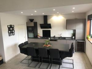 a kitchen with a black table and black chairs at Kaz Ajeya in Les Avirons